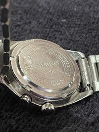 a silver watch on a black background