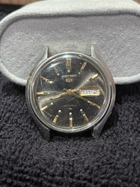 a black and silver watch sitting on top of a box