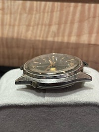a silver watch sitting on top of a box