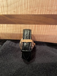a black watch with a rose gold strap