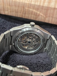 a silver watch with a skeleton on it