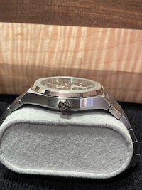 a stainless steel watch on top of a box