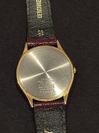 a gold watch with a black leather strap