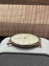 a gold watch sitting on a wooden box