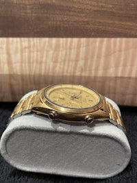a gold watch sitting on a wooden box