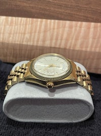 a gold watch sitting on top of a box