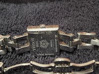 a silver watch with a chain on it