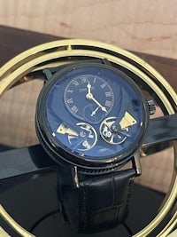 a black and gold watch sitting on a table