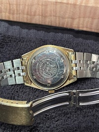 a gold and silver watch on a black cloth