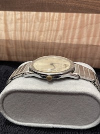 a silver watch sitting on top of a box