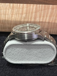 a silver watch sitting on a white box
