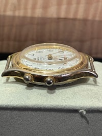 a gold watch sitting on top of a box