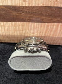 a watch is sitting on top of a cutting board