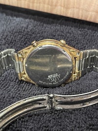 a gold and silver watch with a bracelet on it