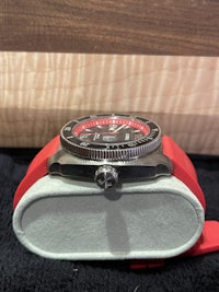 a watch with a red strap and a black case