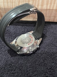 a black and silver watch sitting on a rug