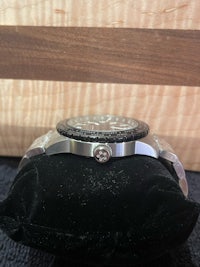 a watch is sitting on a black cushion