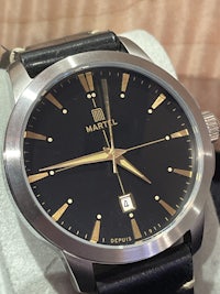 a black and gold watch sitting on a table