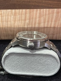 a silver watch sitting on top of a box