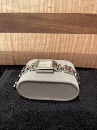 a silver watch sitting on a wooden table