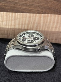 a silver watch sitting on a wooden box
