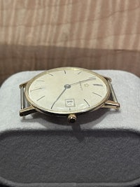 a gold watch sitting in a box on a table