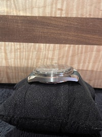 a watch is sitting on a black pillow