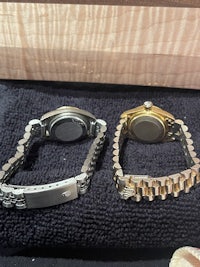 two watches are sitting on a table next to each other