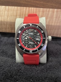 a red and black watch sitting on a table