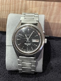 a silver watch sitting on top of a box