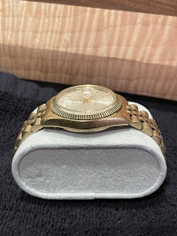 a gold watch sitting on a wooden box