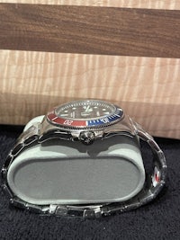a silver watch with a red, white and blue dial