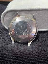 a silver watch sitting on top of a box