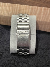a stainless steel bracelet on a wooden table