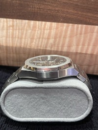 a stainless steel watch sitting on top of a box