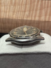 a black and silver watch sitting on top of a box