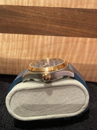 a watch is sitting on a blue leather case