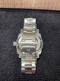 a silver watch on a black background