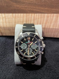 a black watch on a wooden table