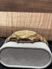 a gold watch sitting on top of a box