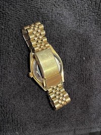 a gold watch on a black towel
