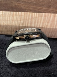 a black and gold watch sitting on a table