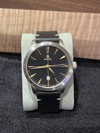 a black and gold watch sitting on a table