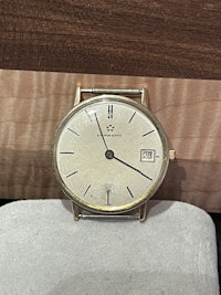 a gold watch sitting on a wooden table