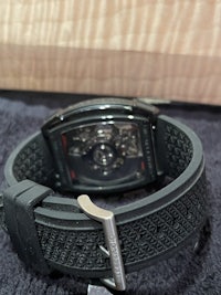 a black watch with a black strap sitting on a table