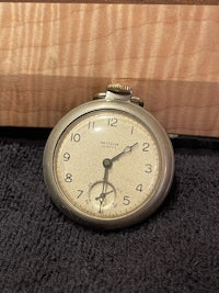 a pocket watch sitting on top of a wooden box