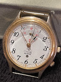a gold watch sitting on a black surface